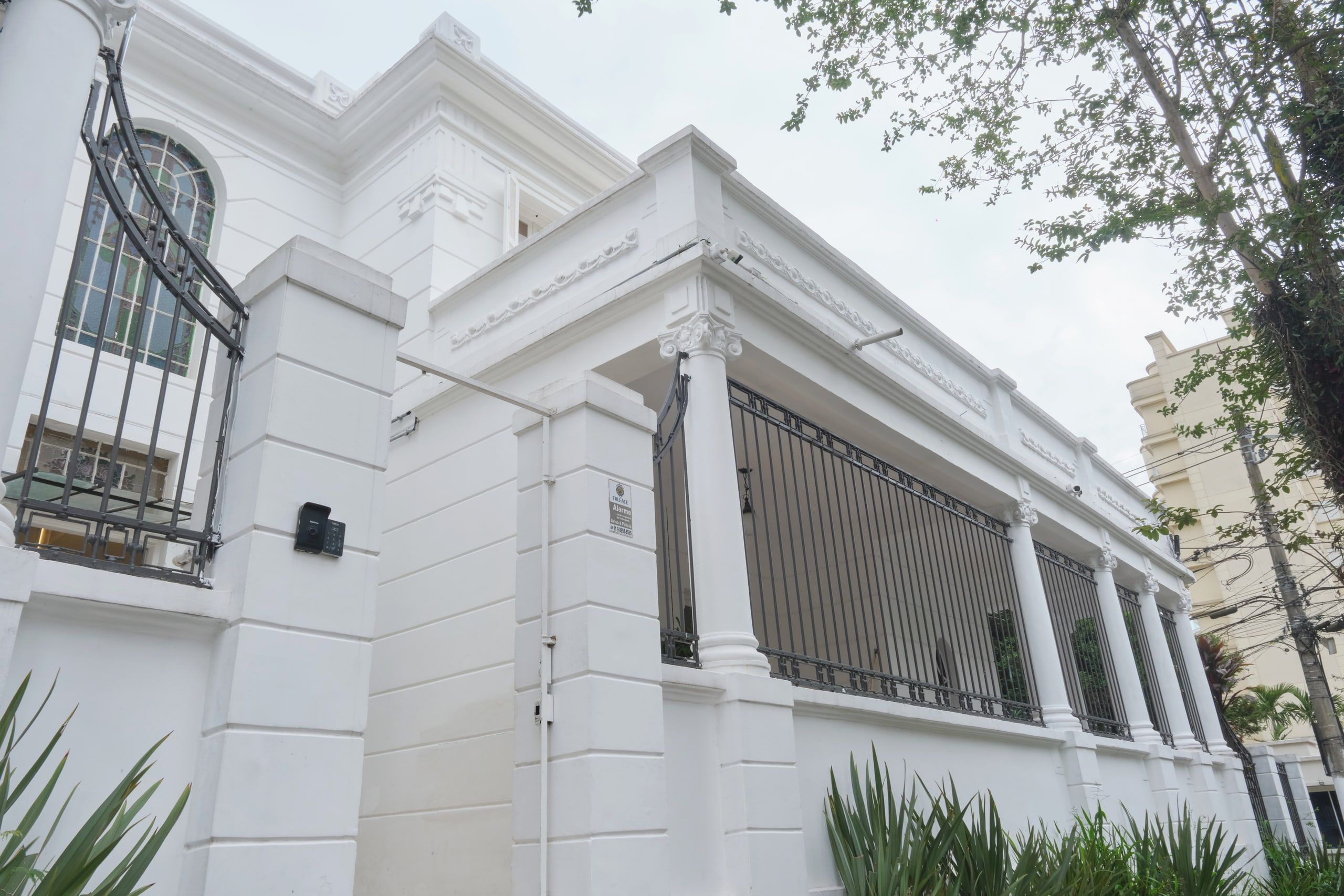 A casa da Phen vista de lado, com a colunata e o jardim