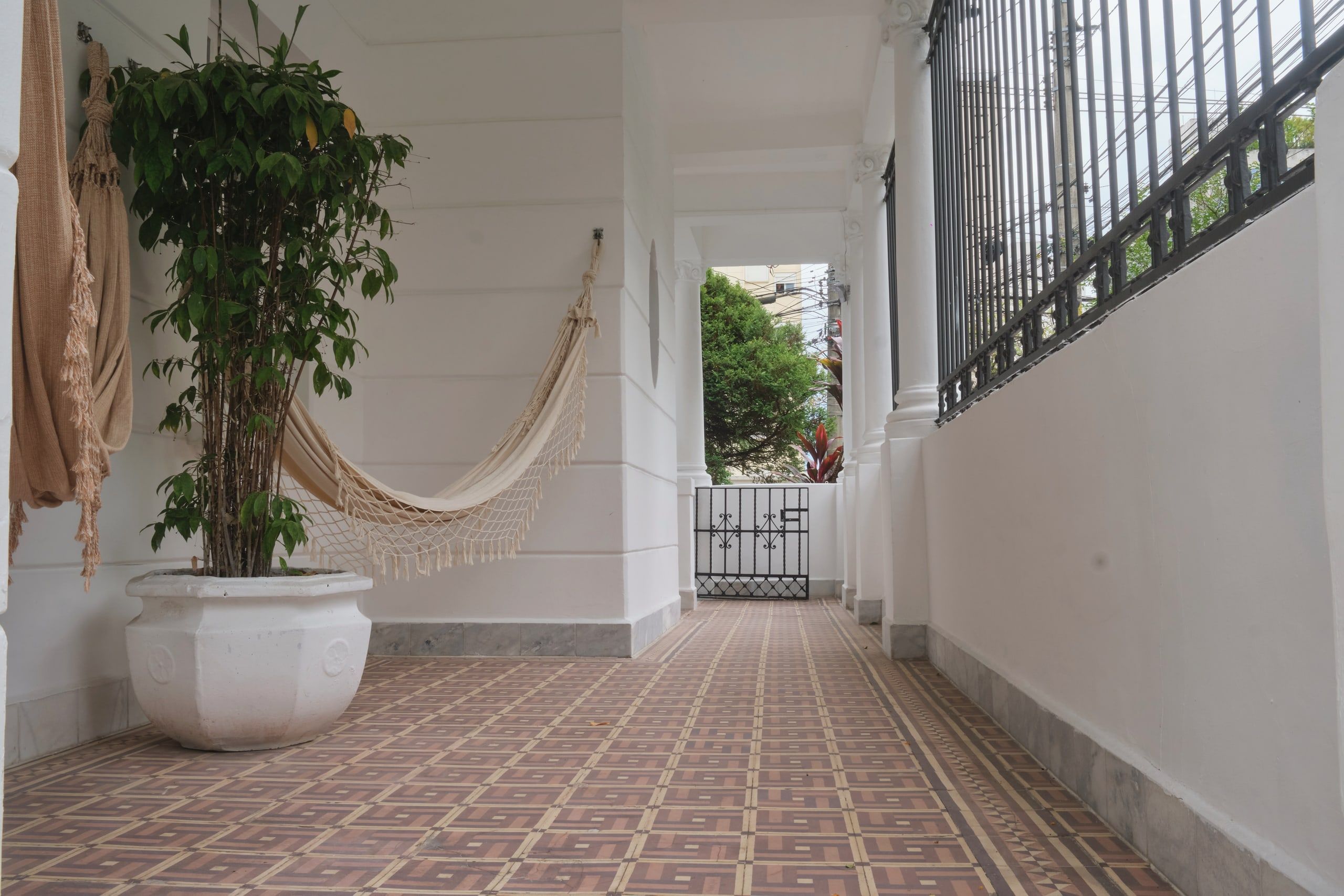 Varanda lateral da casa da Phen, com piso hidráulico e colunata